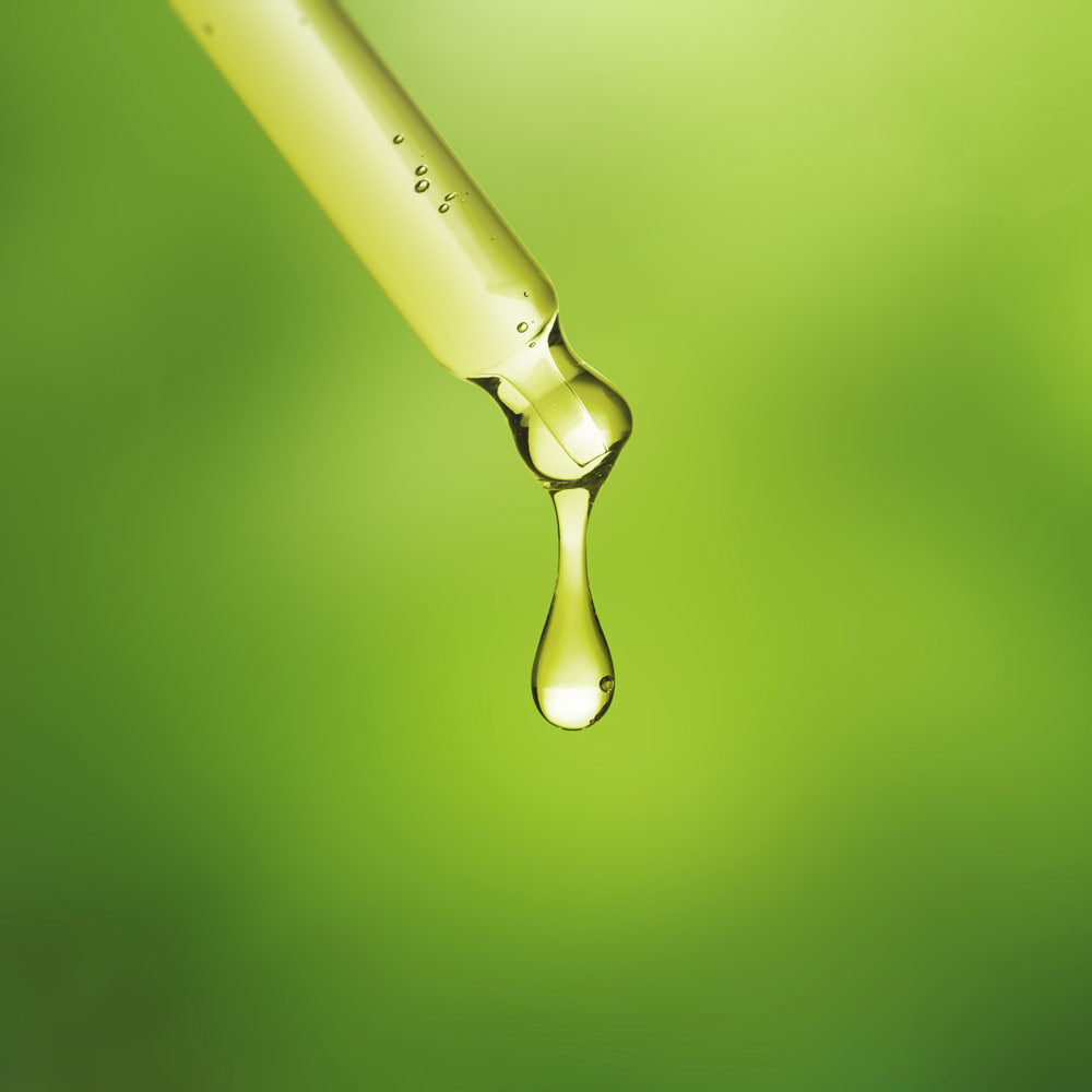 Foto mit grünem Hintergrund Pipette aus der ein Tropfen fällt